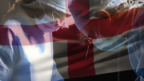 animation of flag of england waving over surgeons in operating theatre