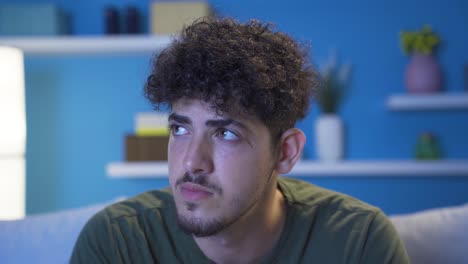 close-up of thoughtful young man at home at night.