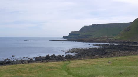 scenic landscape of coastal mountains, calm ocean, and the famous giant's causeway in county antrim, northern ireland