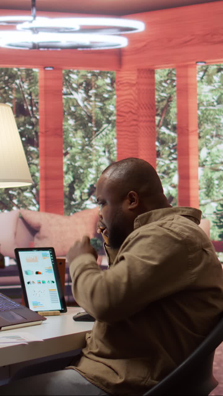 African American Man Talking on Phone While Working in Home Office