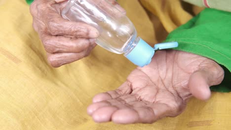 elderly person applying hand sanitizer