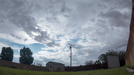 paisaje nublado y lluvia sobre un vecindario suburbano en un patio trasero típico - lapso de tiempo