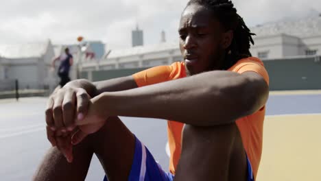 Basketball-player-sitting-with-basketball-in-court-4k