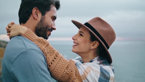 La-Pareja-Se-Divierte-Abrazando-La-Costa-De-Cerca.-Pareja-Sonriente-Parada-Frente-Al-Océano-Gris