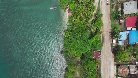 Aerial-top-down-of-car-on-coastal-road-during-sunny-day-on-Biliran-Island