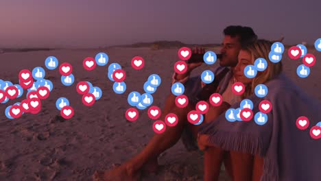 Animation-of-social-media-love-and-like-icons-over-caucasian-couple-drinking-beer-on-beach