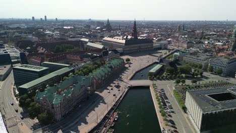 Christiansborg-Palace-and-Borsen-Stock-Exchange-Aerial-Ascent,-Copenhagen,-Denmark