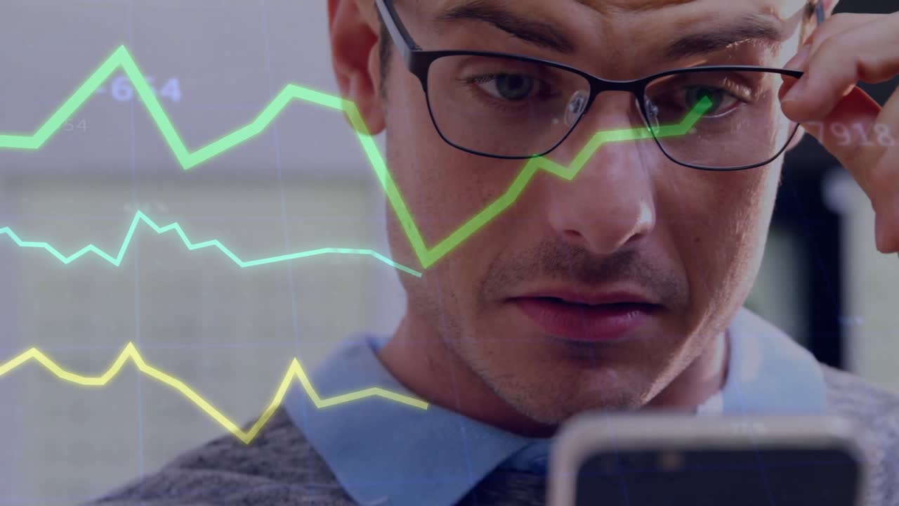 Man holding phone in office viewing stock charts appearing dipping checking stocks adjusting specs