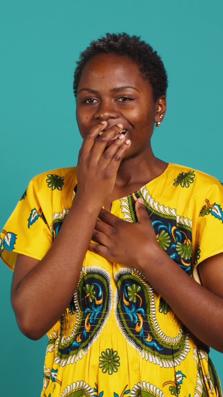 Giovane donna africana che reagisce con sorpresa e divertimento