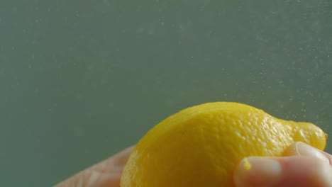 man peels lemon zest with peeler