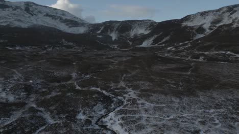 The-rugged-terrain-and-snow-capped-peaks-at-the-quiraing-on-the-isle-of-skye,-scotland,-in-winter,-aerial-view