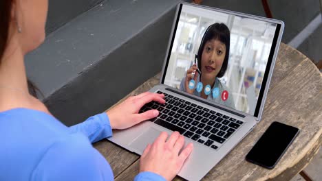 Caucasian-woman-using-laptop-on-video-call-with-female-colleague-working-from-home