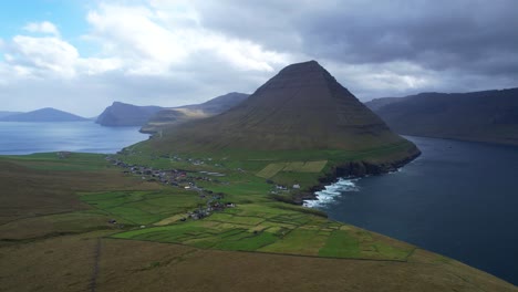 aerial of vidareidi village between malinsfajll mount and the ocean, 4k