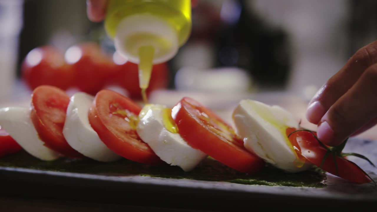 verter aceite de oliva sobre tomates y queso