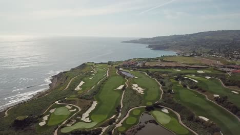 Drone-Shot-of-Breathtaking-Golf-Course-in-Los-Angeles-California-right-on-the-Ocean-at-Sunset-on-a-Beautiful-Warm,-Sunny-Day-Overlooking-the-Cliffs