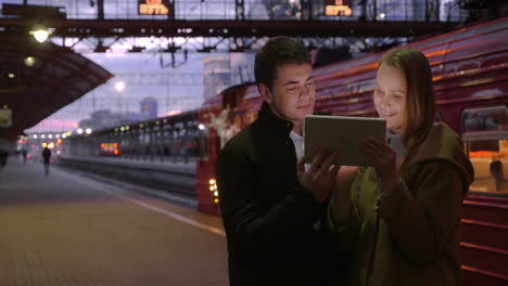 man and woman with pad at the station