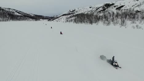 snowmobiling on a frozen lake in a mountainous landscape