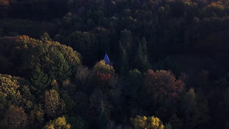 Drohne-Schwenkt-Bei-Farbenprächtigem-Sonnenuntergang-Im-Herbst-Um-Die-Hütte-Im-Wald-Herum