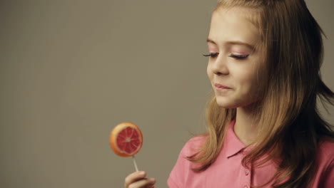 beautiful little girl with a lollipop in hands
