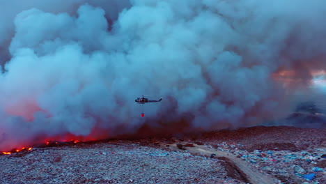aerial view of a helicopter water drop on burning grasslands, african wildfires, in middle of thick smoke, dark evening, in south africa - pan, drone shot