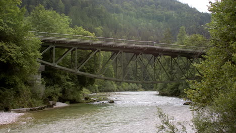 historische eisenbahnbrücke über einen kristallklaren alpinen fluss in österreich