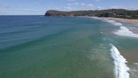 Surfers-Floating-On-Sea-Waves,-Basking-Under-The-Sun-At-The-Copacabana-Beach-In-New-South-Wales,-Australia