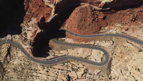 Aerial-view-above-traffic-on-a-winding-desert-road,-golden-hour-in-Southwest-USA