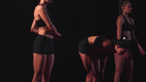 tres chicas vestidas de negro están en las plataformas de salida para comenzar la carrera en la competencia.