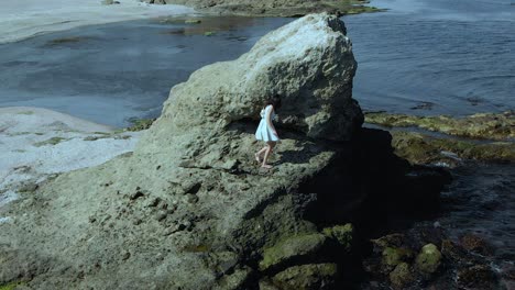 Chica-Guapa-Con-Vestido-Blanco-Sube-Un-Gran-Acantilado-A-Orillas-Del-Mar---59