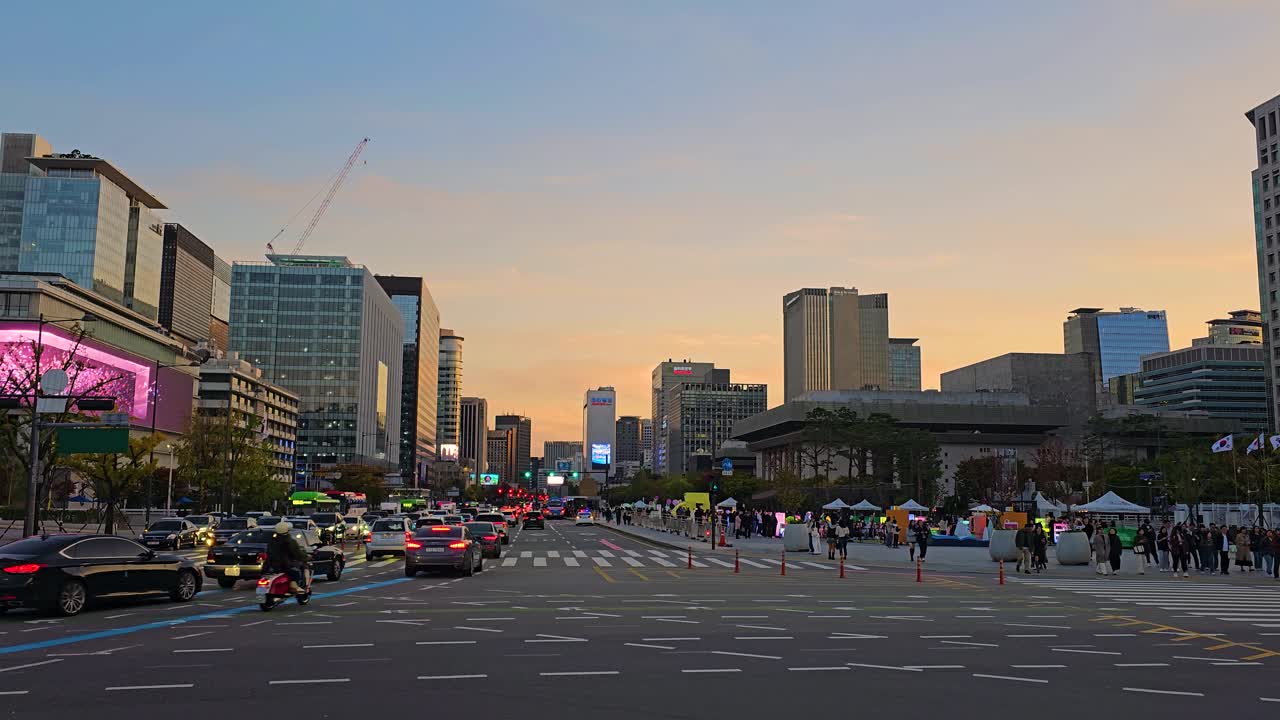 Seoul City Car Traffic by Gwanghwamun Square At Sunset, Crowd of People Sightseeing, Majestic Downtown Skyscraper Building Against Colorful Sky