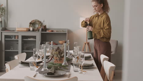 woman pouring wine in glasses before christmas