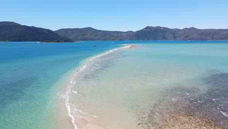 las olas del océano se encuentran en la lengua de arena larga de la isla de langford - paisaje marino en las islas whitsunday, qld, australia