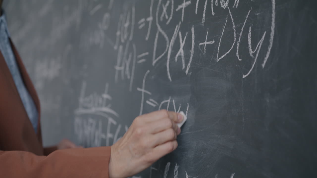 Teacher writing equations on a chalkboard