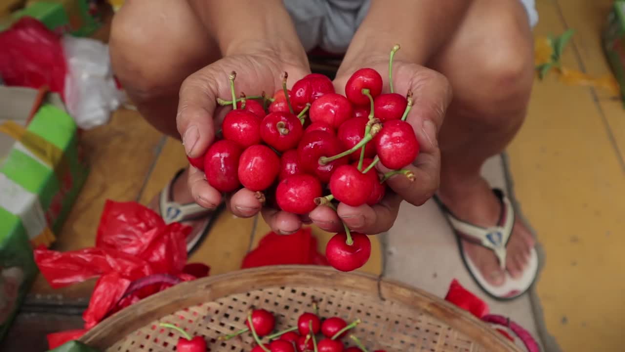 hands of man holding up cherries