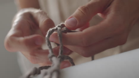 mujer tejiendo macrame en casa