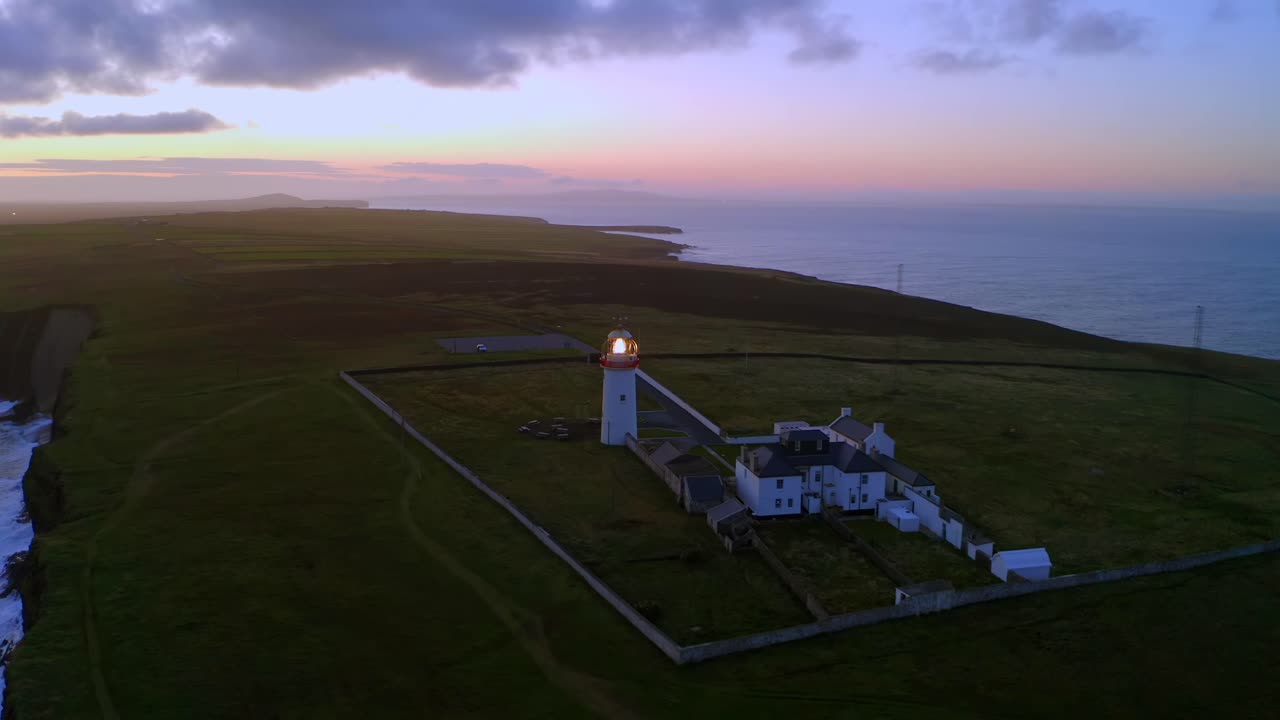 따뜻한 황혼 하늘을 배경으로 새벽에 빛나는 루프 헤드 등대
