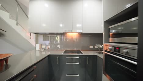 minimalist modern kitchen with sleek furnishings and natural lighting in a contemporary home. interior of house home staged for real estate.
