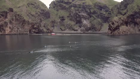 Kayakistas-Remando-Junto-A-Increíbles-Acantilados-De-La-Costa-Islandesa-De-Heimaey