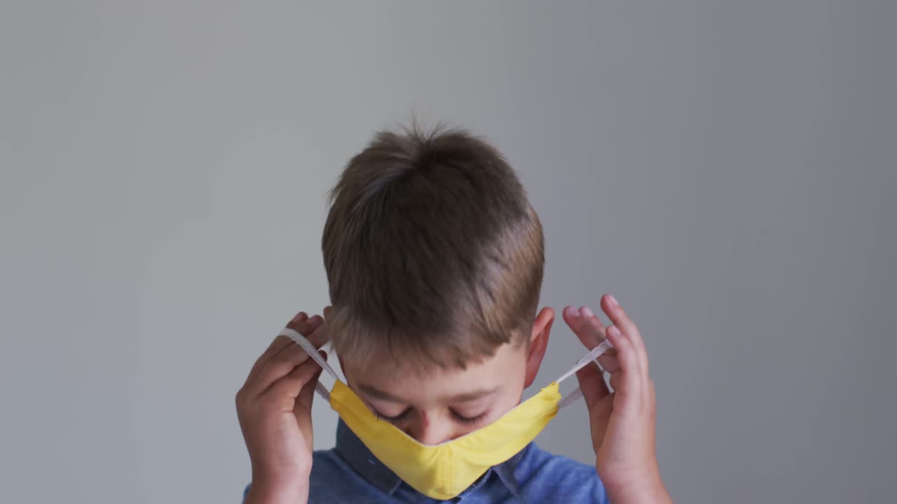 노란색 얼굴 마스크를 쓰고 있는 백인 소년의 초상화