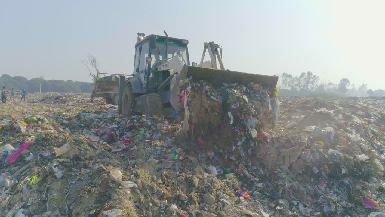 baleado en la planta de gestión de residuos sólidos, haridwar, uttarakhand, india vertido de basura utilizando una máquina jcb en la planta de gestión de residuos sólidos