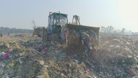 baleado en la planta de gestión de residuos sólidos, haridwar, uttarakhand, india vertido de basura utilizando una máquina jcb en la planta de gestión de residuos sólidos