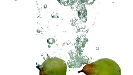las peras se sumergen en el agua sobre un fondo blanco