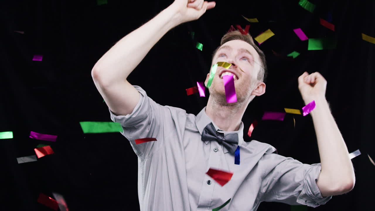 행복한 남자가 콘페티로 축하하고 있습니다.