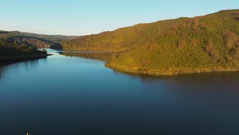 autumn foliage surrounding encoro da ribeira on eume river in spain