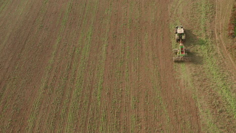 Toma-Aérea-Cenital-Sobre-Un-Tractor-Arando-A-La-Derecha-Del-Cuadro.