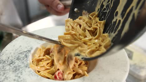 chef preparing a plate of creamy pasta