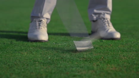 golfer feet hitting ball on fairway course. golf man swinging shot on training.