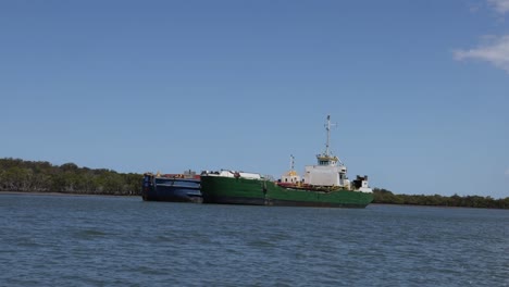 un remolcador maniobra una gran barcaza en un río