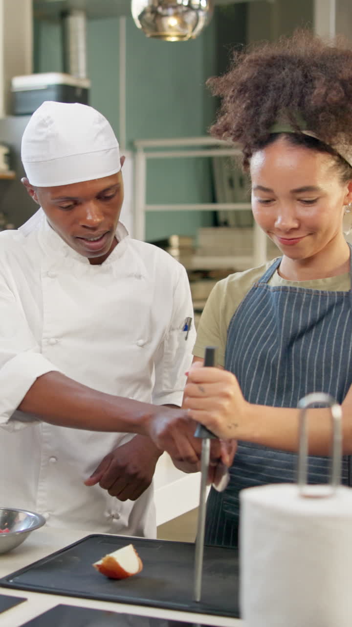 Chef instructing woman on knife skills