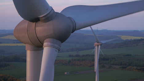 three wind turbines slowly turning at sunset surrounded by scottish countryside, aberdeenshire